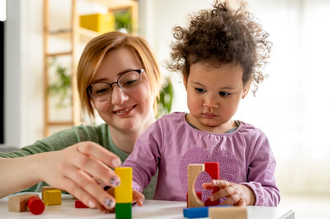   Rodzic jako pomoc nauczyciela dziecka z niepełnosprawnością ruchową w przedszkolu. Na zdjęciu pomoc nauczyciela w przedszkolu