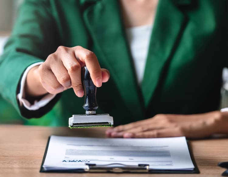 Podanie o zapomogę z ZFŚS - jak napisać. Na zdjęciu: Na zdjęciu: Pracownik podbija pieczątkę na dokumentach.