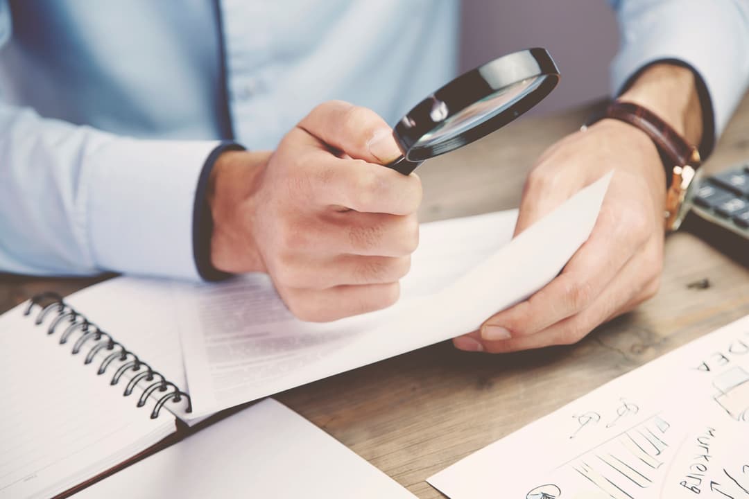 Oświadczenie o dochodach do ZFŚS. Na zdjęciu: dokument pod lupą. 