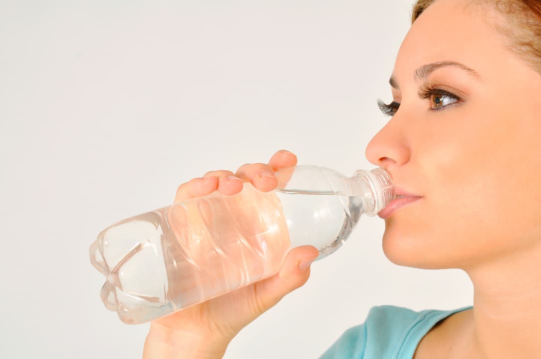 Napoje i środki czystości w przedszkolu. Na zdjęciu: pani pije wodę