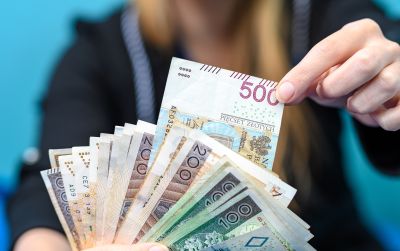 Prawo do dofinansowania z ZFŚS dla nauczyciela przechodzącego na emeryturę — jak uniknąć podwójnego wniosku o wypoczynek? Na zdjęciu: pieniądze