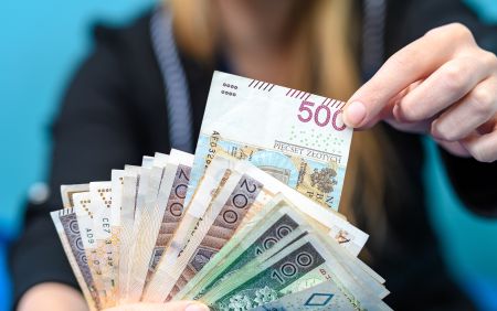 Prawo do dofinansowania z ZFŚS dla nauczyciela przechodzącego na emeryturę — jak uniknąć podwójnego wniosku o wypoczynek? Na zdjęciu: pieniądze