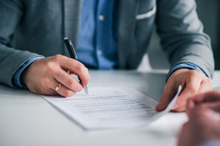 Zakres informacji o warunkach zatrudnienia dla pracownika z zagranicy. Na zdjęciu: podpisywanie dokumentu. 